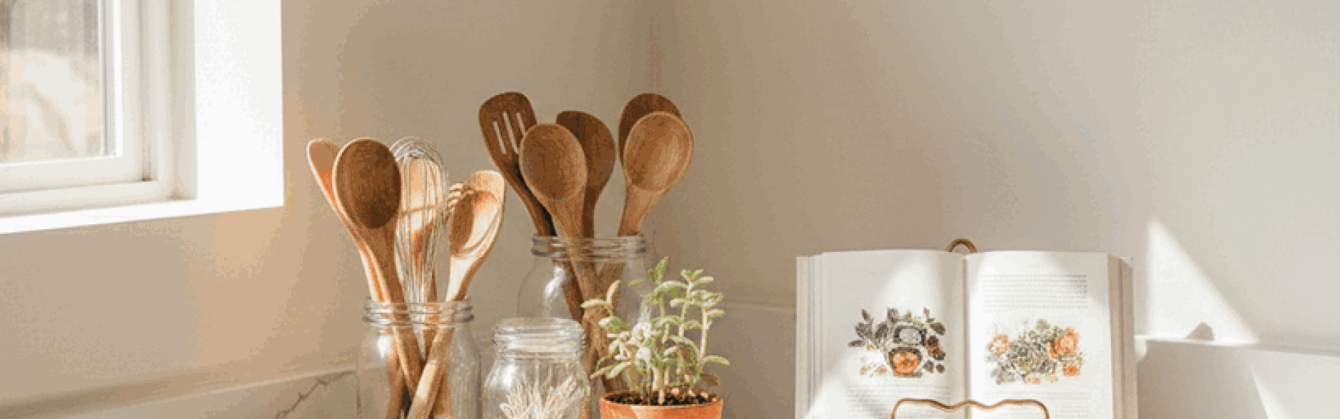 Modern kitchen counter corner decorated with tray, plant, and cookbook stand for a cozy and stylish look.